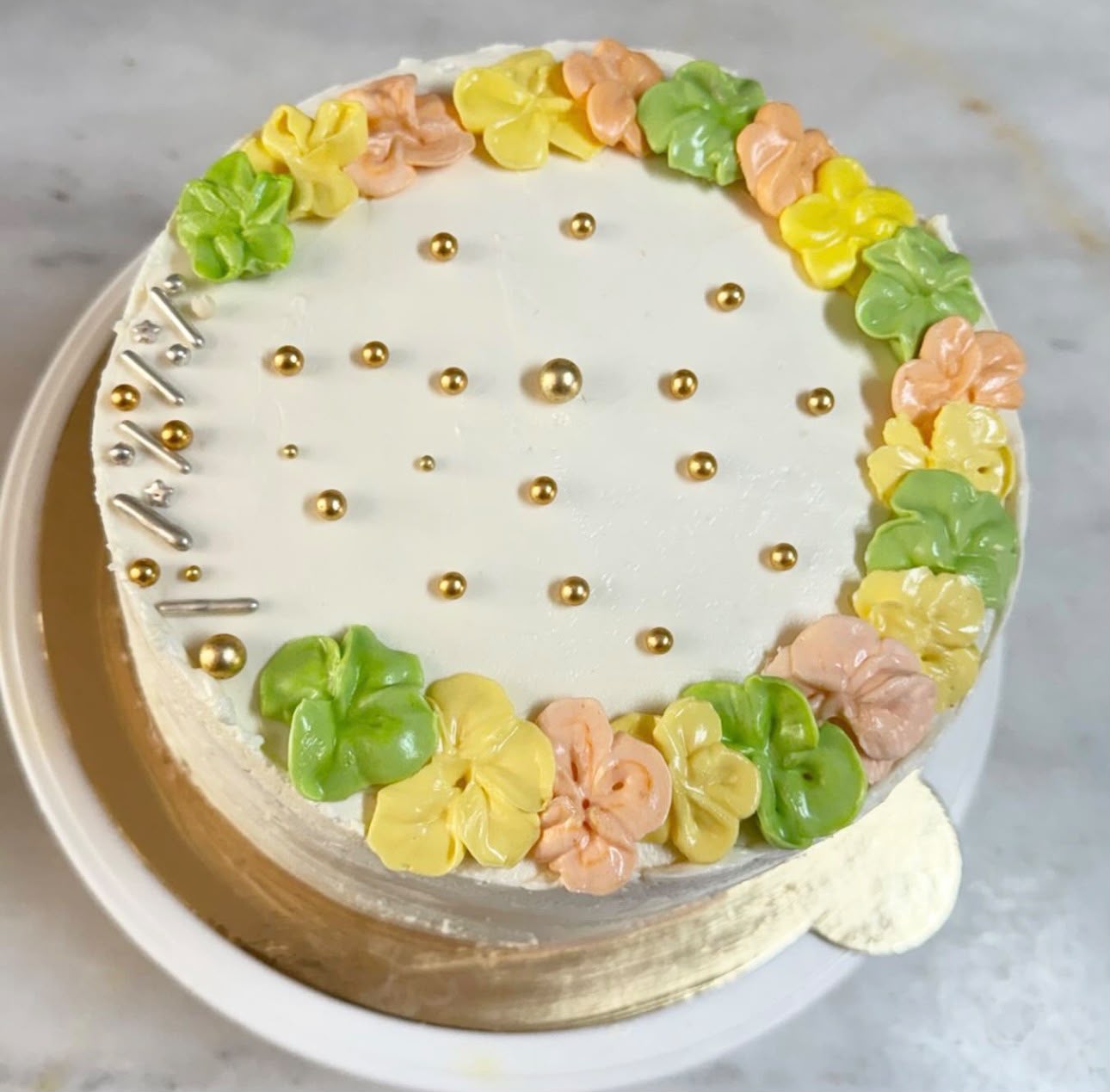 Pastel çiçek çelenkli altın incili pasta